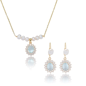 Detailed shot of jewelry set featuring freshwater pearls and light blue zircon pendants