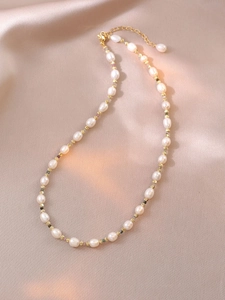 Gros plan sur un collier de perles d'eau douce avec tourmalines sur tissu de soie