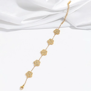 Détail du bracelet fleuri doré avec zircons et fermoir mousqueton réglable à cœur