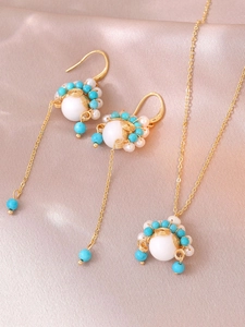 Detailopname van Peking Opera stijl ketting met witte parels en gouden draadkwastjes
