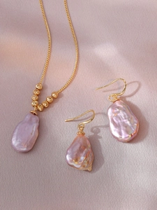 Gros plan détaillé de l'ensemble collier et boucles d'oreilles perles d'eau douce.