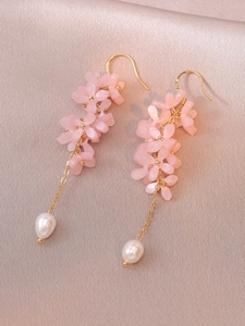 Macro detail of S925 silver flower earrings with pink petals and baroque drop pearls