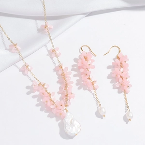 Elegant gold necklace and earring set featuring pink petals and baroque pearls