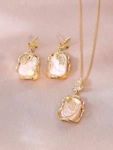 Detailed close-up of Baroque pearl jewelry set with gold leaf accents and small crystals