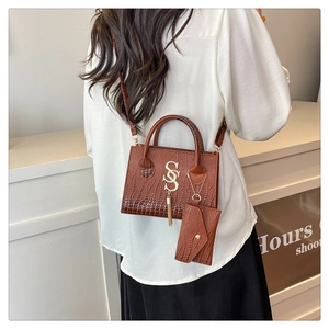 Detailed back view of a brown crocodile pattern crossbody bag with a tassel and coin purse