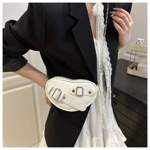 Détail du sac cœur en cuir blanc avec boucle métallique et bandoulière en chaîne