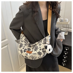 Borsa tote in tela con stampa orientale e charm a panda indossata a spalla dal modello