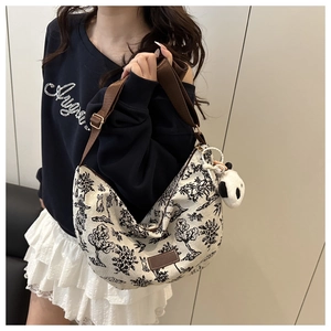 Dettaglio della borsa hobo in tela con stampe naturali e un ciondolo a forma di panda