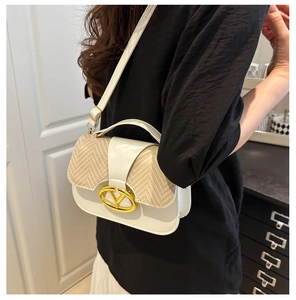 Detail shot of the gold V-logo buckle and textured weave on a luxury crossbody bag