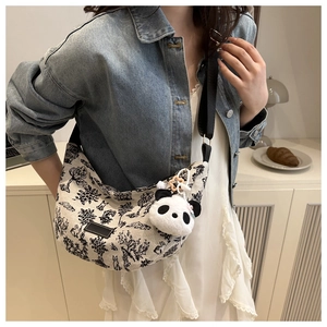 Borsa hobo in tela bianco sporco con stampe vintage e ciondolo panda su modella