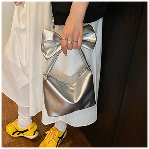 Metallic silver handbag featuring a prominent oversized bow detail and metal chain strap
