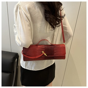 Detail view of red faux-crocodile leather bag with elegant gold twist lock and fine texture