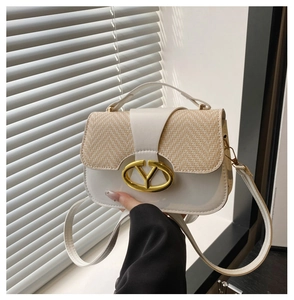 Detail of white leather and straw weave mini bag with golden V-shaped metal logo buckle