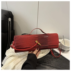Detail of red crocodile texture handbag with an elegant golden knot metal clasp