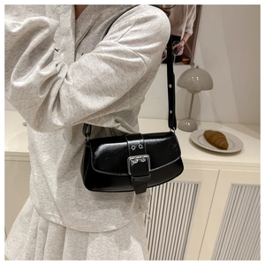 Chic black glossy faux leather underarm bag with decorative silver buckle on model
