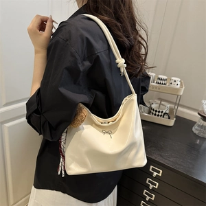 Schicke cremeweiße glänzende Schultertasche mit silberner Schleife und Knotengurt