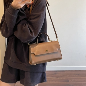 Brown vintage PU leather shoulder bag with golden bow hardware shown on a model