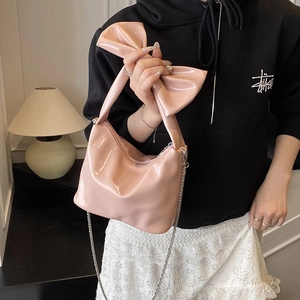 Pink patent leather handbag with oversized bow handle and silver chain strap for women