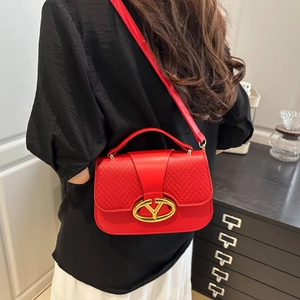 Red saddle shoulder bag with woven leather detail and gold metal hardware shown on model
