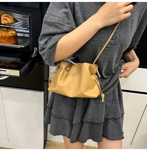 Detail of yellow cloud bucket bag with drawstring closure and heart metal pendant