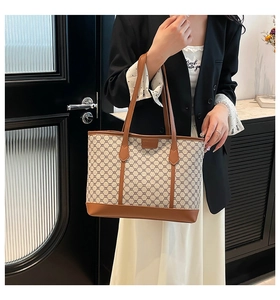 Detail of vintage geometric pattern tote bag with leather straps and logo plate