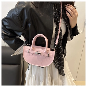 Pink semi-circle handbag with silver twist lock shown on model for style and size