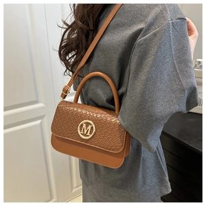 Sac à main marron avec rabat crocodile et logo M doré porté en bandoulière chic