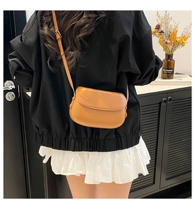 Brown leather saddle bag showing adjustable shoulder strap and body size in use