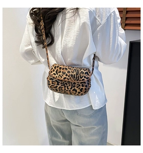 Close-up of leopard print crossbody bag showing textured pattern and brown leather piping