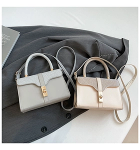 Detail of elegant two-tone tote bags featuring golden swivel locks and fine stitching