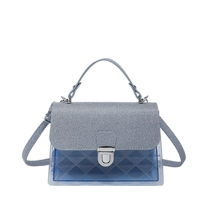 Sac à main bleu en PVC avec rabat tissé et texture matelassée losange sur fond blanc épuré