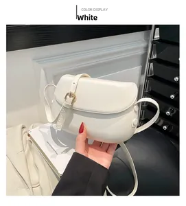 Close-up of white leather saddle bag with golden buckle and sleek side button details