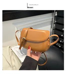 Close-up of brown leather saddle bag featuring a gold buckle and adjustable strap detail