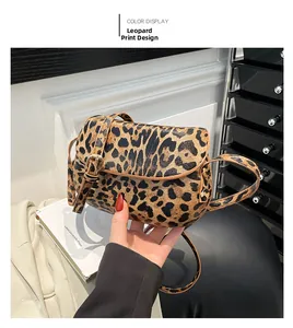 Detail view of leopard print saddle bag with adjustable strap and metal buckle closure