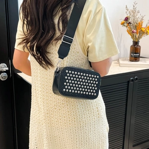 Black rectangular crossbody bag with silver studs and adjustable wide strap