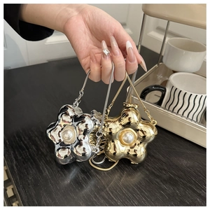 Detailed macro view of mini flower metal purses with large pearls and snake chains