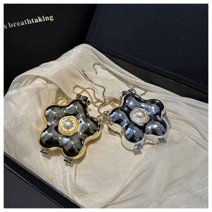 Close-up of pearl flower charm in gold and silver finish with polished mirror surface