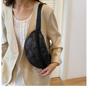 Detail einer schicken schwarzen Strass-Gürteltasche mit Kette und Nylonriemen am Modell