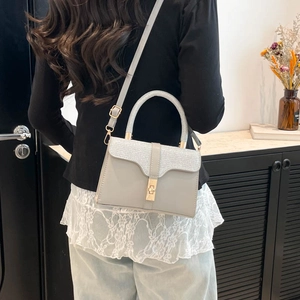 Gray leather and woven fabric crossbody bag with gold buckle and top handle