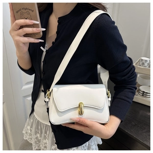 Detail showing white leather square bag with unique asymmetric flap and gold metal lock