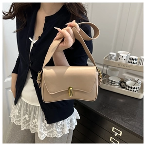 Detailed view of beige saddle-shaped shoulder bag with golden metal buckle clasp