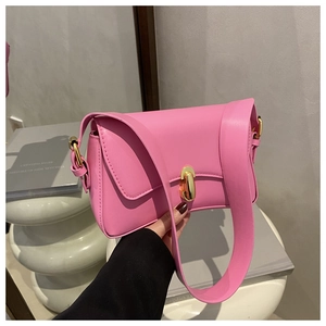 Detailed view of pink leather handbag featuring a stylish gold oval metal buckle lock