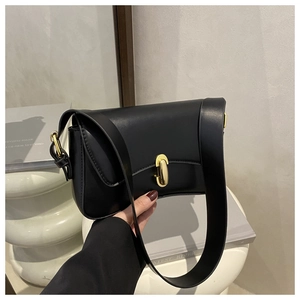 Detailed view of black faux leather shoulder bag with elegant gold oval metal buckle clasp
