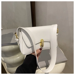 Detail of white minimalist square bag showing sleek faux leather and gold oval clasp