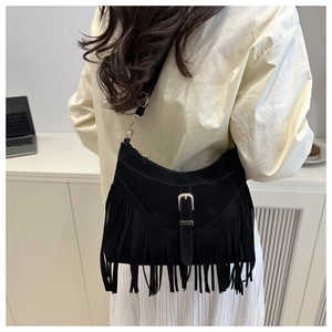 Detail shot of the matte black suede shoulder bag featuring long fringe and a gold buckle