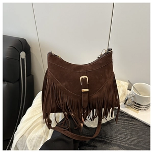Detailed close-up of dark brown suede fringe and vintage belt buckle on tote bag
