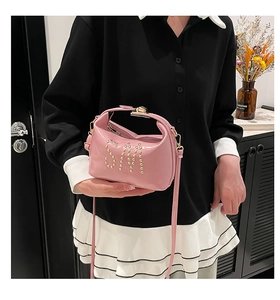 Détail du sac à main en cuir verni rose avec rivets dorés et finition brillante