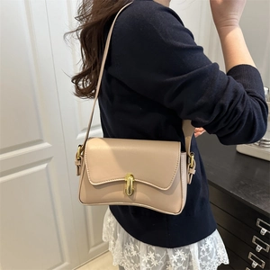 Chic beige leather square shoulder bag with gold twist lock shown on a female model