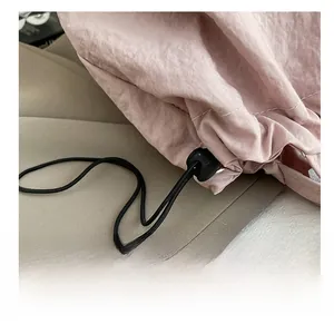Dettaglio della fibbia nera regolabile e delle cuciture sulla borsa tote in tela rosa