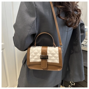Close-up of brown leather and white quilted fabric texture on the stylish crossbody bag